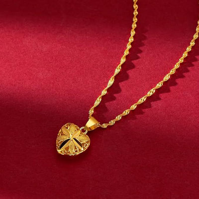 Gold necklace with a heart-shaped pendant on a red background