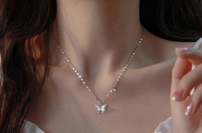 Butterfly necklace worn by a person with a blurred background